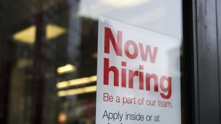 In this Jan. 4, 2019, file photo, a "now hiring" sign hangs on the door of a Staples store in New York City.