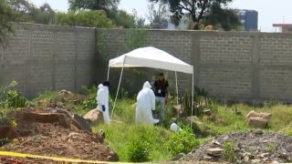 Peritos forenses recuperan restos de una fosa