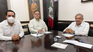 El presidente de México (d) con dos funcionarios sentados a una mesa
