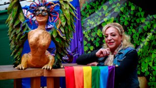 Figura de un alebrije, figura fantástica típica de México y la bandera de la comunidad LGBT acompañan a una de las candidatas a diputada federal