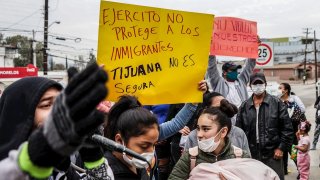 MIGRANTES protestan inseguridad en México "Ejército no proteje a los inmigrantes... Tijuana no es segura" lee un letrero.