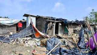 Un hombre parado junto a una casa que fue destruida por el ciclón Mocha, en la isla de Shahpori, en las afueras de Teknaf, el 15 de mayo de 2023.