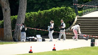 Oficiales de policía trabajan dentro de un área acordonada tras el apuñalamiento de varios niños en un parque infantil de la ciudad de Annecy, Francia, el viernes.