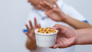 Foto ilustrativa de niño rechazando alimentos por alergias al maní.