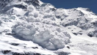 Una avalancha retumba por una empinada ladera de montaña.