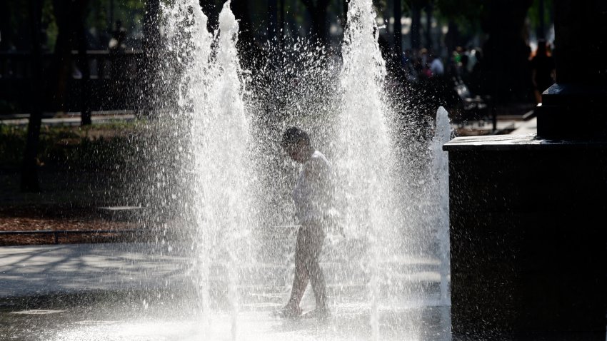 Un niño se refresca mojándose en una fuente en el centro histórico de México debido a las altas temperaturas.