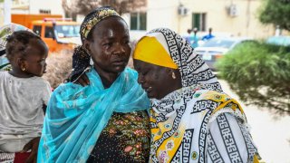 Familiares se consuelan entre sí mientras llegan para recibir tratamiento tras una ola de ataques suicidas en el noreste de Nigeria, en Maiduguri, el 29 de junio de 2024.