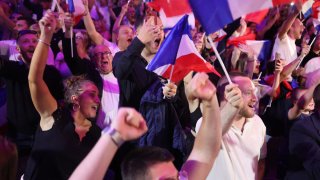 Partidarios reaccionan mientras la expresidenta del grupo parlamentario de extrema derecha francés Rassemblement National (RN), Marine Le Pen, da un discurso durante la noche de los resultados de la primera vuelta de las elecciones parlamentarias en Henin-Beaumont, en el norte de Francia, el 30 de junio de 2024.