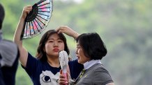 Dos mujeres usan ventiladores para refrescarse durante un día caluroso en Hanoi, Vietnam, el 2 de julio.