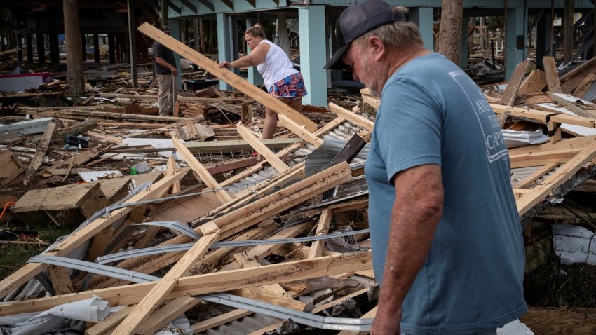 Kiki Keen and his father Clinton Keen walk among the debris of their family’s beach house, following Hurricane Helene in Horseshoe Beach, Florida, U.S., September 28, 2024. 