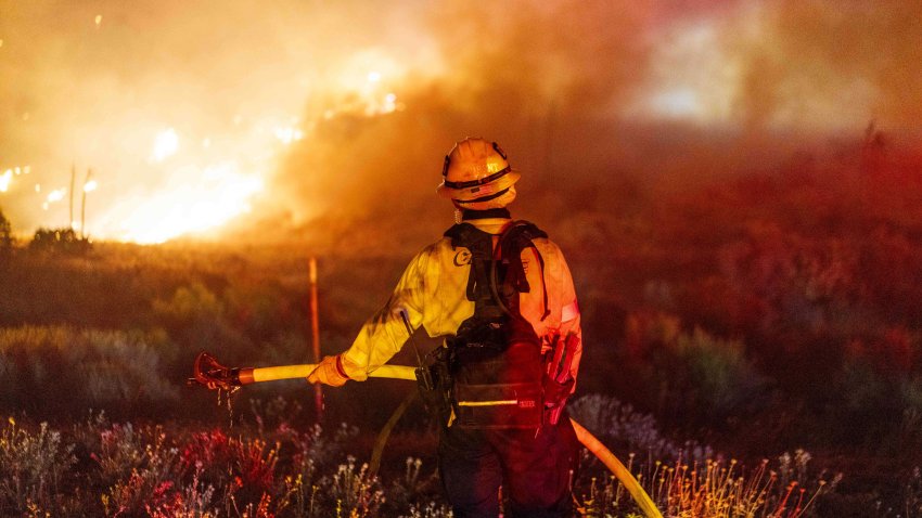 A firefighter monitors the Post Fire near Gorman, California, US, on Sunday, June 16, 2024. A fast-moving wildfire that started Saturday afternoon along Interstate 5 near the Grapevine has charted a path south and as of nightfall was moving toward the town of Castaic, reported the Los Angeles Times. Photographer: Kyle Grillot/Bloomberg via Getty Images