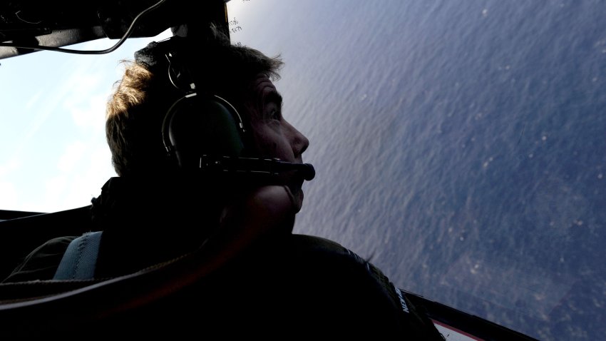 IN FLIGHT – APRIL 11: Co-pilot and Squadron Leader Brett McKenzie of the Royal New Zealand Airforce (RNZAF) P-3K2-Orion aircraft, helps to look for objects during the search for missing Malaysia Airlines flight MH370 in flight over the Indian Ocean on April 13, 2014 off the coast of Perth, Australia. Search and rescue officials in Australia are confident they know the approximate position of the black box recorders from missing Malaysia Airlines Flight MH370, Australian Prime Minister Tony Abbott said on Friday. At the same time, however, the head of the agency coordinating the search said that the latest “ping” signal, which was captured by a listening device buoy on Thursday, was not related to the plane.  (Photo by Greg Wood – Pool/Getty Images)