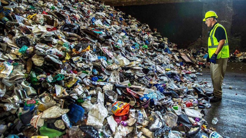 Carmelo Andino, an operations supervisor, inspects a pile of mix unsorted recycled materials, including plastic, cardboard and paper, at the Waste Management Recycling Plant in Pembroke Pines, Florida, on Friday April 8, 2022. (Pedro Portal/El Nuevo Herald/Tribune News Service via Getty Images)