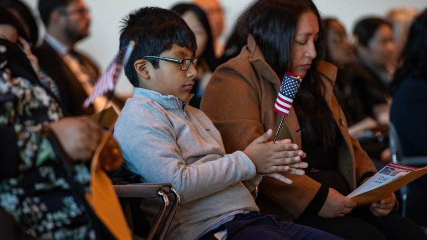 Un niño sostiene una bandera de EEUU durante una ceremonia de naturalización en la sala de reunión del jurado en la Corte John Joseph Moakley de los Estados Unidos en Boston, Massachusetts, el 8 de enero de 2025.