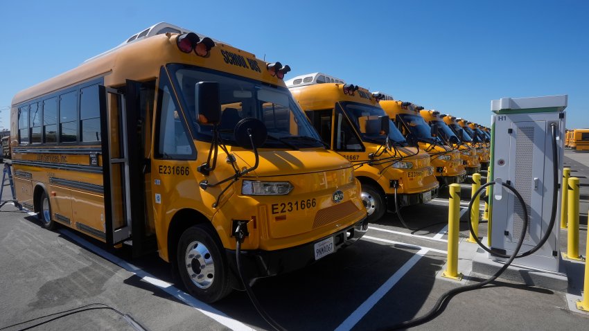 Autobuses eléctricos Zum en estaciones de carga, antes de una conferencia de prensa para anunciar que el distrito escolar de Oakland será el primero en el país en que usar 100% autobuses eléctricos, en la instalación Zum/OUSD en Oakland, California el 27 de agosto del  2024. (AP foto/Jeff Chiu)