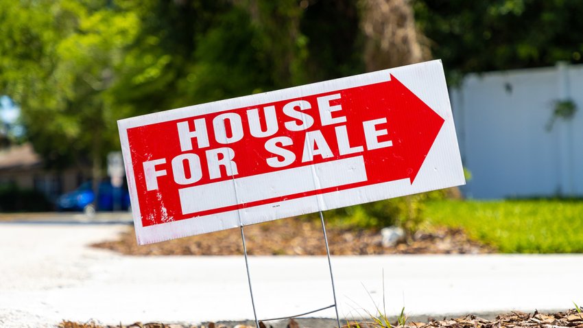 House for sale real estate sign on a street in a neighborhood