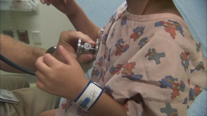 Un niño siendo examinado por un médico por tos ferina.